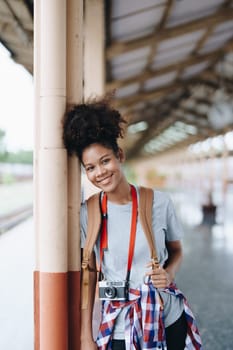 Tourists african american are showing happy expressions while waiting for their journey in the train station