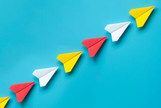 Top view of red, white and yellow paper on blue background