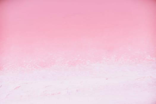 Woman in pink salt lake. She in a white dress and hat enjoys the scenic view of a pink salt lake as she walks along the white, salty shore, creating a lasting memory