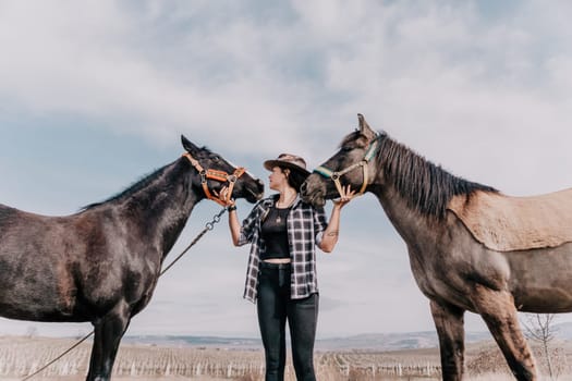 Cute happy young woman with horse. Rider female drives her horse in nature on evening sunset light background. Concept of outdoor riding, sports and recreation.