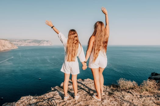 Close up portrait of mom and her teenage daughter hugging and smiling together over sunset sea view. Beautiful woman relaxing with her child.