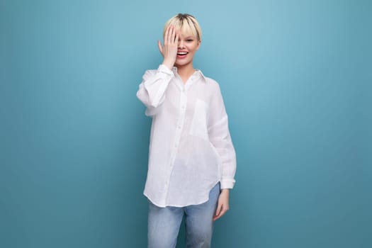 young pretty caucasian blond career woman in white blouse isolated on blue background with copy space.