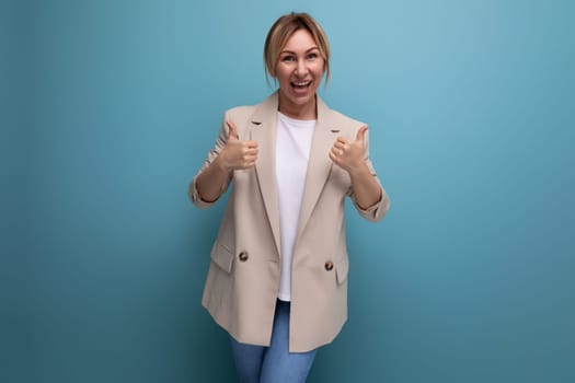 close-up of a European blonde young woman in a beige jacket with a grimace on her face in the studio.