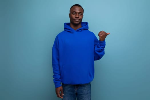 portrait of 30s dark-skinned african man in hooded sweatshirt with emotions of doubt and denial on studio background with copy space.