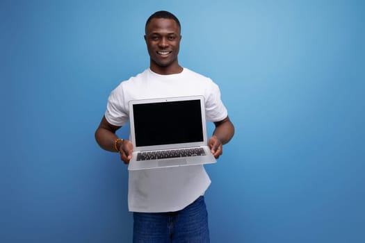 successful handsome black young american freelance guy in white t-shirt with laptop.