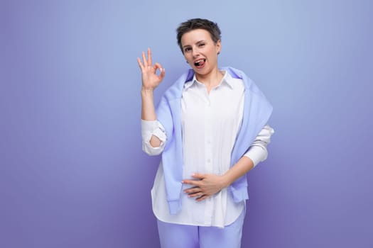 portrait of casual young brunette woman with short haircut in white shirt pointing finger.