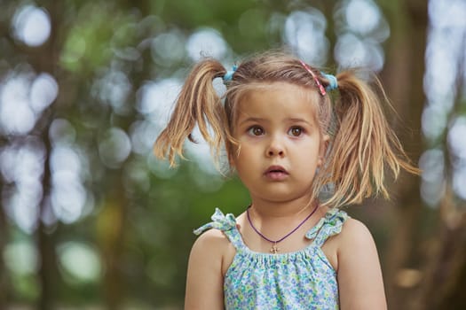 Adorable surprised child in the garden in Denmark.