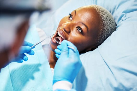 Dentist, inspection and woman with tools in mouth at clinic for cavity, teeth whitening and helping hand for pain. Dental surgeon, African patient and mirror for exam, care or check for healthy smile.