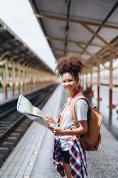 Asian teenage girl african american traveler dressed in casual wear holding map and searching right direction of route