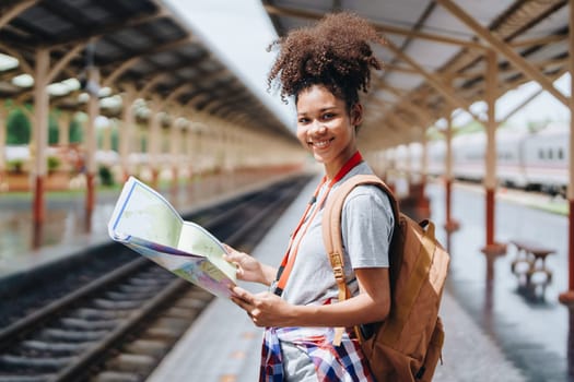 Asian teenage girl african american traveler dressed in casual wear holding map and searching right direction of route