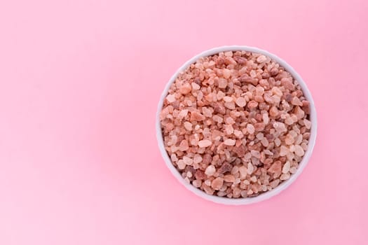 Mockup Pink Himalayan Rock Salt, Halite In White Ceramic Bowl On Pink Background. Top View Horizontal Plane, Copy Space For Text. High quality photo.