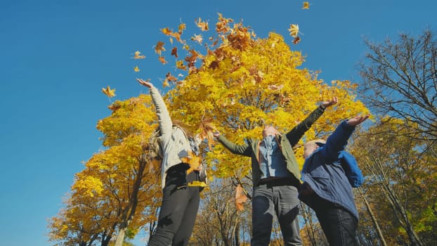 A young, happy family in the park sprinkled with leaves