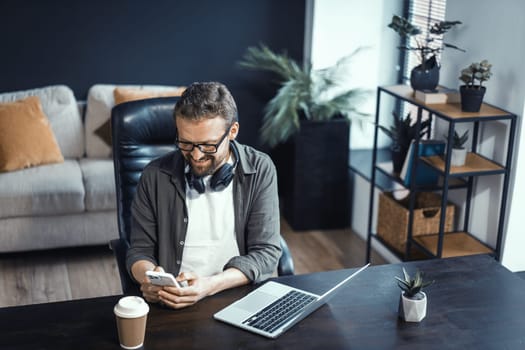Concept of working from home, featuring mid-aged man working on laptop. Man seen in comfortable home office environment, highlighting convenience and benefits of working from comfort of one's own space. High quality photo