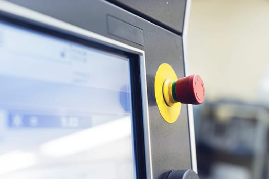 Industrial control console with touch screen and joystick with emergency stop button. Selective focus