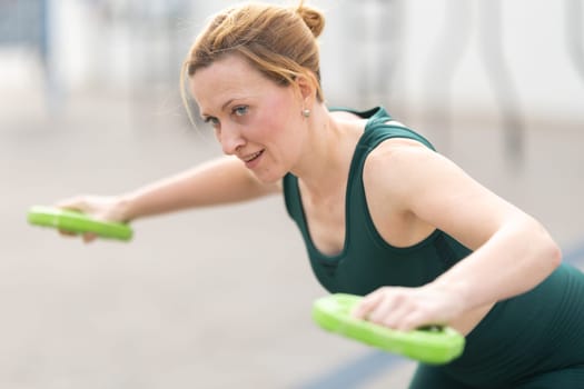 Adult athletic woman with no make up lifting weights. Mid shot