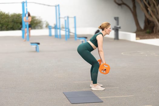 Adult sportive woman exercising with a dumbbell. Mid shot