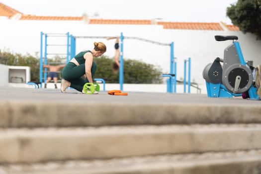 Adult sportive woman exercising at the outdoors sports ground. Mid shot