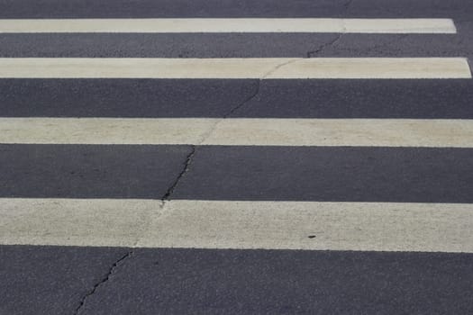 Photo of footpath white stripes on gray asphalt. Road traffic. Road coverage.