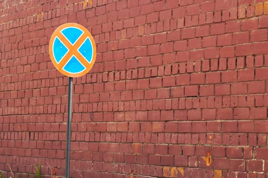 Photo red brick wall and road round crossed out sign. No Parking. Traffic Laws.