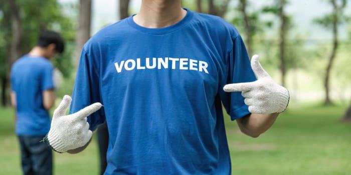 Close up young man volunteering wearing t-shirt with volunteer message.