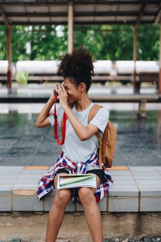 Asian teenage girl african american traveling using a camera take a photo to capture memories while waiting for a train at the station