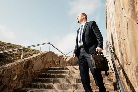 Business executive with briefcase going down the stairs.