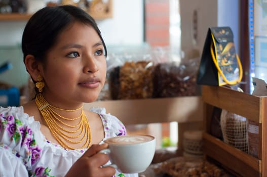 young and pretty indigenous woman with a coffee in her hand looking through the window of a cafeteria. High quality photo
