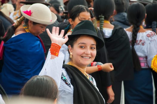 Otavalo, Ecuador - 24 de junio de 2023: smiling indigenous woman from otavalo waving with her open hand in the middle of a parade. High quality photo