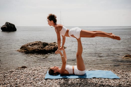 Woman sea yoga. Back view of free calm happy satisfied woman with long hair standing on top rock with yoga position against of sky by the sea. Healthy lifestyle outdoors in nature, fitness concept.