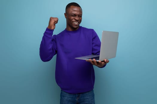 successful handsome young american business man in blue sweatshirt with laptop.