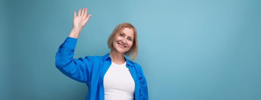 smiling blonde middle-aged woman with bob haircut on studio background.