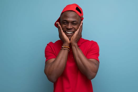 young American man dressed in corporate attire consisting of a baseball cap and a cotton T-shirt.