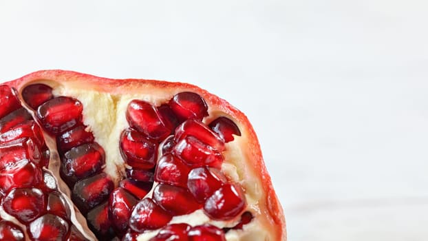 Detail of pomegranate (Punica granatum) insidem with light, almost white background (space for text)