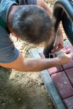 A worker during the installation of a new bench in a city park. New bowls for sitting and relaxing outdoors.