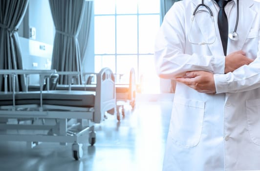Doctor in lab coat with arms crossed on hospital interior background. Medical concept. Medical information search concept. Disease treatment concept. insurance concept.