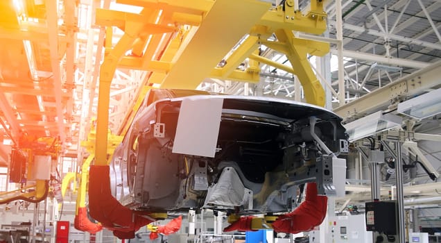 Photo of automobile production line. Modern car assembly plant. Modern and high-tech automotive industry. Conveyor of auto bodies