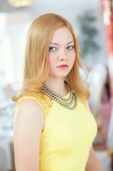 Portrait of beautiful red-haired young woman posing in restaurant
