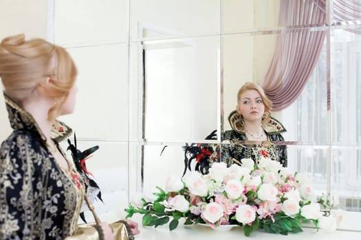 Portrait of young actress posing looking at her reflection in mirror