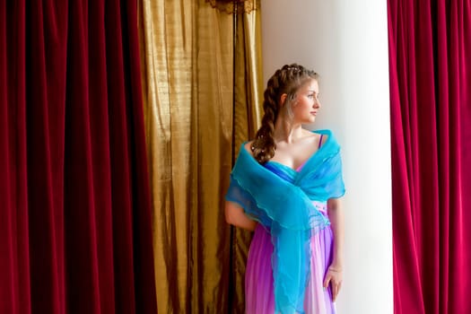 Image of beautiful elegant girl posing standing near column
