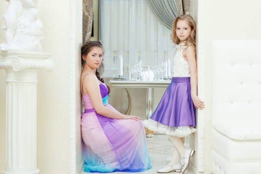 Image of enchanting young models posing in elegant dresses