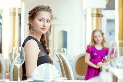Image of pretty young sisters posing at restaurant