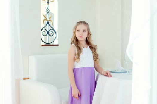 Image of serious cute little girl posing at table, close-up