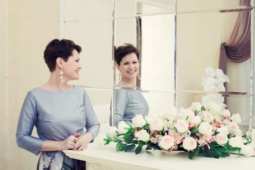 Cheerful middle aged woman laughing in mirror, close-up