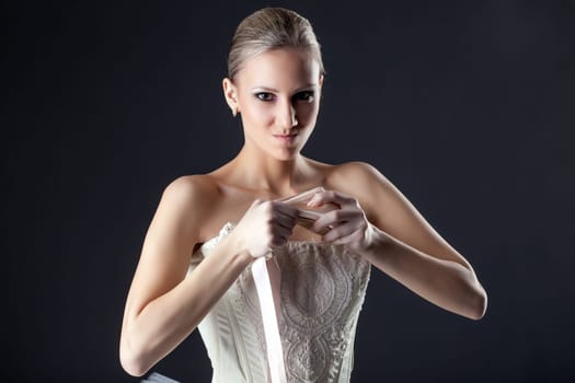 Portrait of emotional ballerina kneads pointe in studio