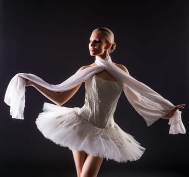Portrait of cute young woman posing like ballerina in studio