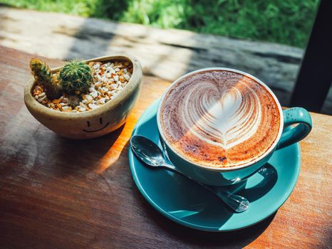 Vintage color,coffee cup with heart shape latte art on wood table