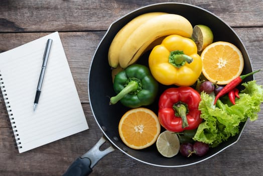 fresh vegetables and fruits for fitness dinner on wooden background top view, food concept