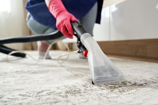 Close-up Of A Person Cleaning Carpet With Vacuum Cleaner