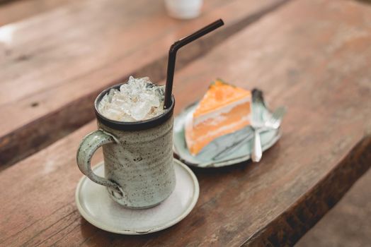 ice coffee and orange cake on the wooden background