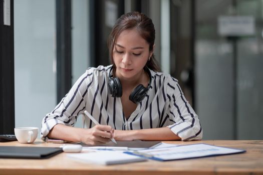 Portrait asian woman designer working with digital tablet on workplace at home,